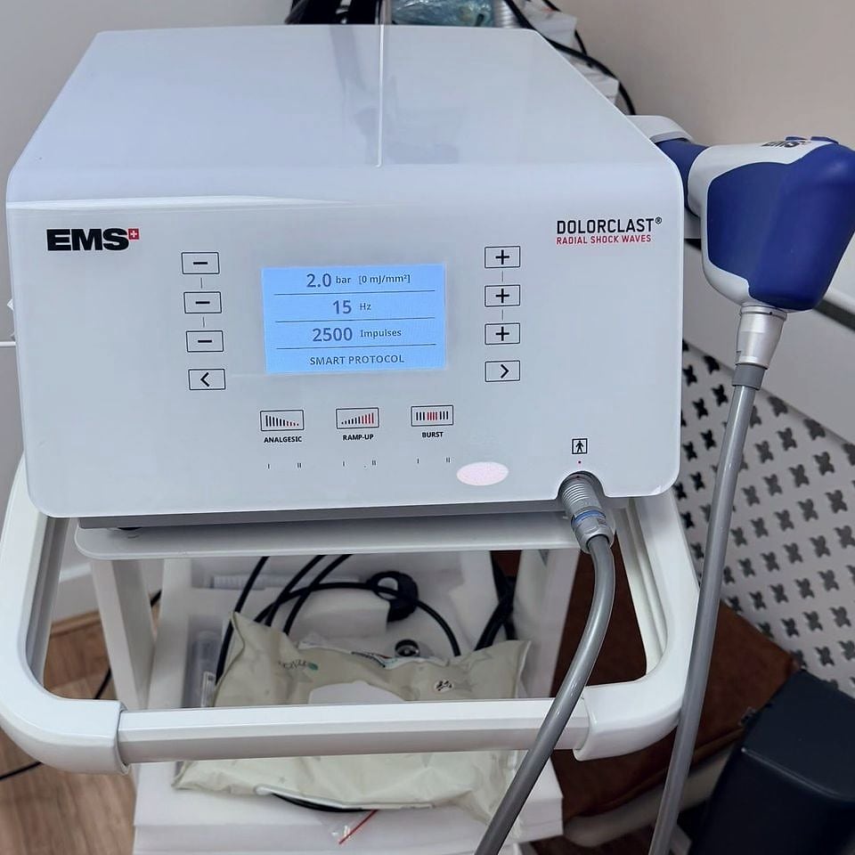 The EMS Dolorclast radial shockwave unit at PRC Clinic, with its blue applicator handpiece.
